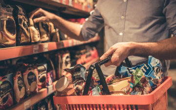 homem fazendo compras em um supermercado segurando