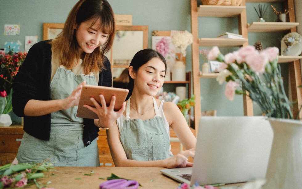 duas mulheres empresárias uma olhando para um tablet e outra para um notebook