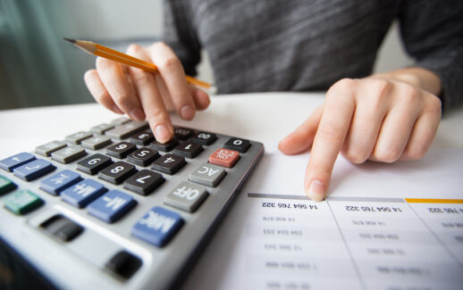 Close de uma pessoa usando a calculadora para calcular os impostos da Reforma Tributária.