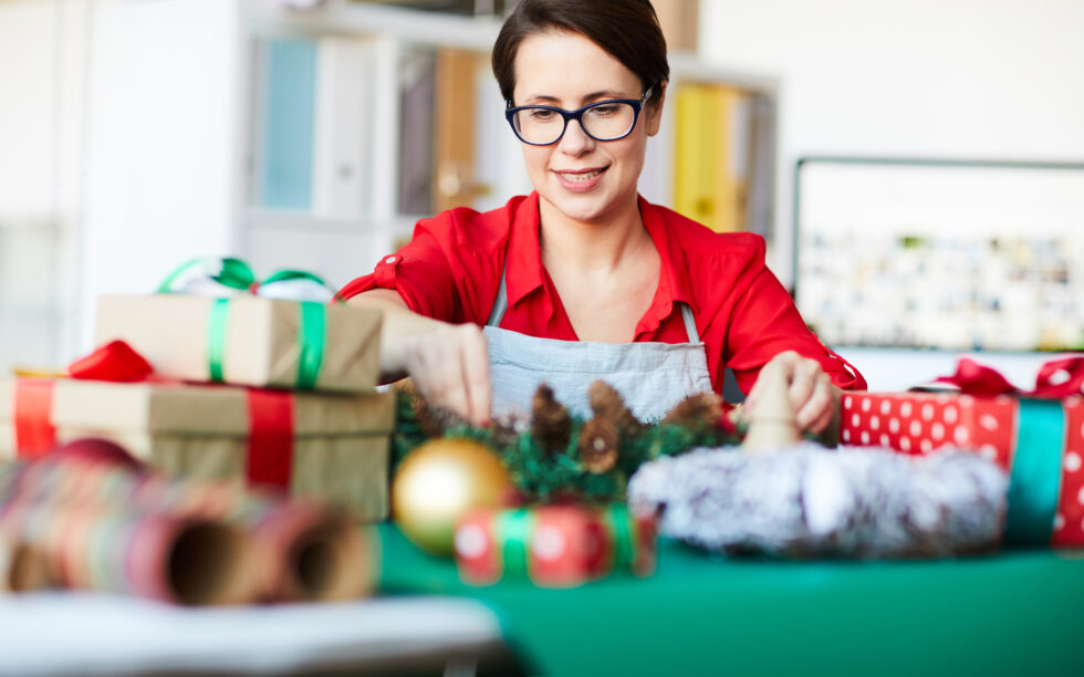 Vendedora organizando a decoração de Natal da sua loja.