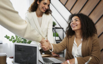 Parceiras de trabalho se cumprimentam fechando negócio.